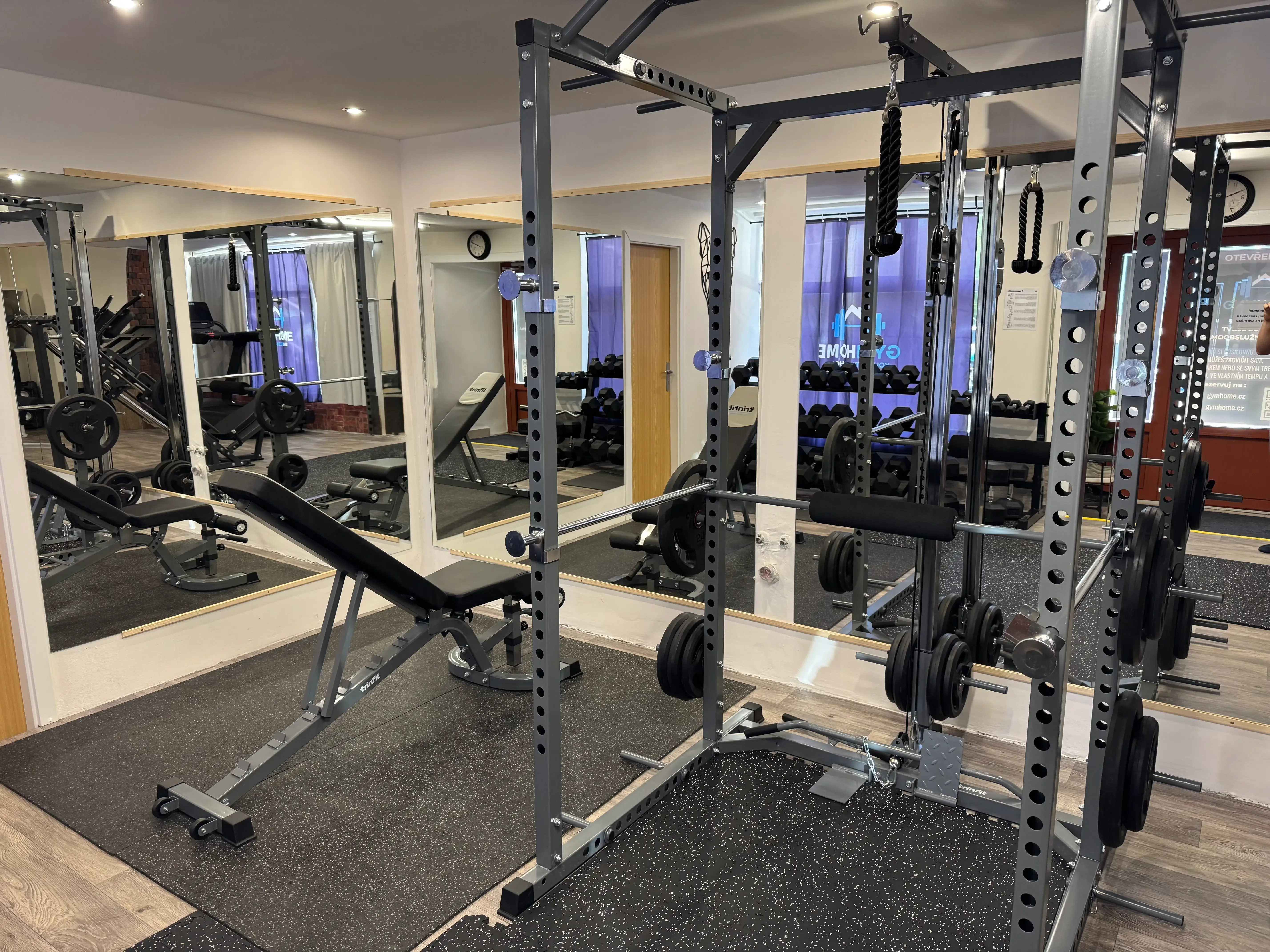 Vybavená posilovací klec s lavicí a adaptéry na kladku vám umožní bezpečně procvičit celé tělo. Ideální volba pro silový trénink, dřepy, bench press i přítahy.